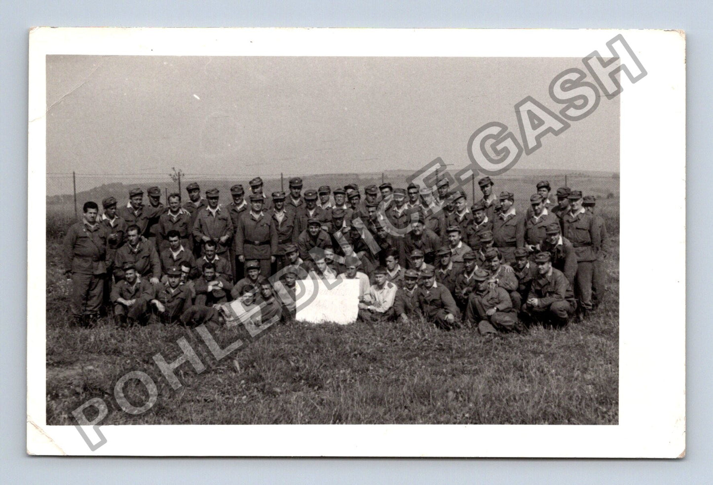 Stará fotografie skupina vojáků v poli s bílým objektem (M38700)