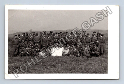 Stará fotografie skupina vojáků v poli s bílým objektem (M38700)