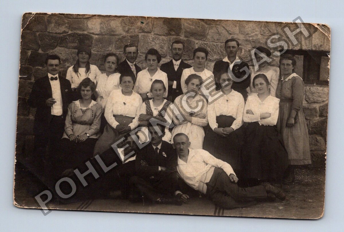 Pohlednice skupinová fotografie lidí u kamenné zdi (M40389)