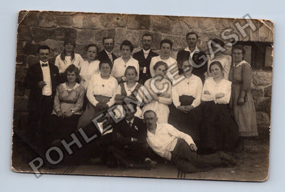 Pohlednice skupinová fotografie lidí u kamenné zdi (M40389)