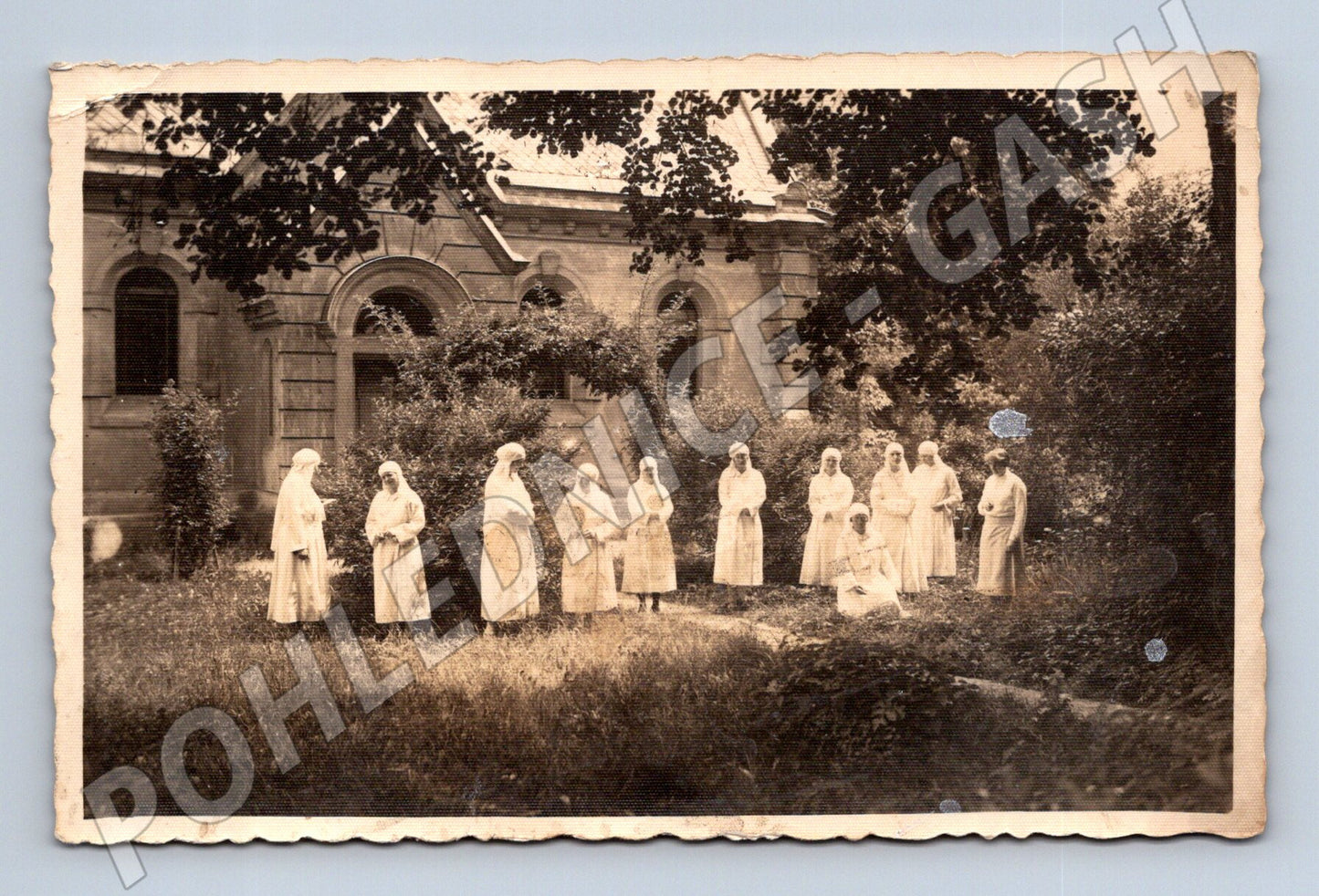 Postcard of a nun at a historic building (M9476)
