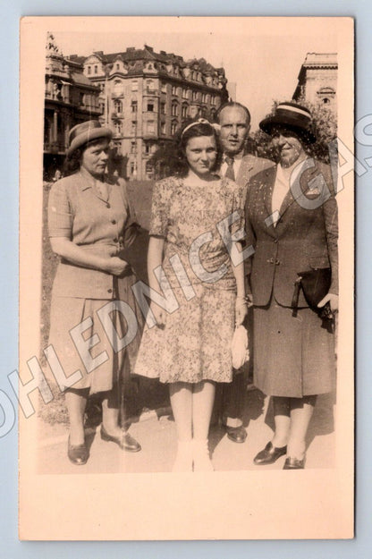 Stará fotografie skupina čtyř lidí s budovami (P3187)